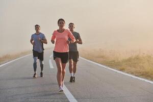 A group of friends, athletes, and joggers embrace the early morning hours as they run through the misty dawn, energized by the rising sun and surrounded by the tranquil beauty of nature photo