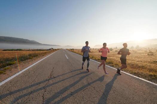 A group of friends, athletes, and joggers embrace the early morning hours as they run through the misty dawn, energized by the rising sun and surrounded by the tranquil beauty of nature photo