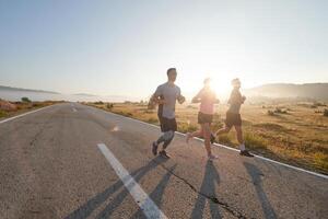 A group of friends, athletes, and joggers embrace the early morning hours as they run through the misty dawn, energized by the rising sun and surrounded by the tranquil beauty of nature photo