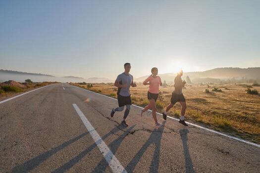 A group of friends, athletes, and joggers embrace the early morning hours as they run through the misty dawn, energized by the rising sun and surrounded by the tranquil beauty of nature photo