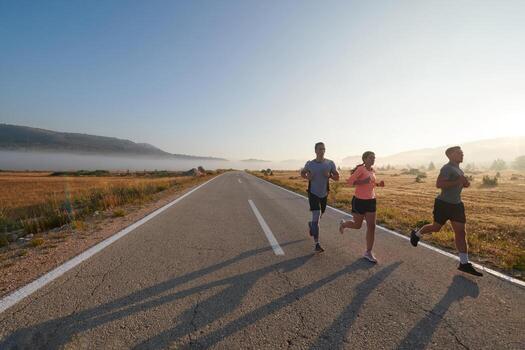 A group of friends, athletes, and joggers embrace the early morning hours as they run through the misty dawn, energized by the rising sun and surrounded by the tranquil beauty of nature photo
