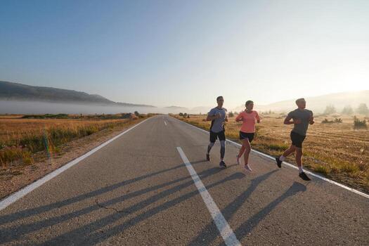 A group of friends, athletes, and joggers embrace the early morning hours as they run through the misty dawn, energized by the rising sun and surrounded by the tranquil beauty of nature photo