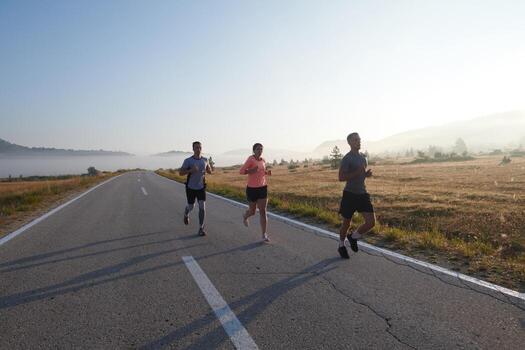 A group of friends, athletes, and joggers embrace the early morning hours as they run through the misty dawn, energized by the rising sun and surrounded by the tranquil beauty of nature photo
