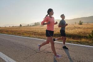 energizado por el belleza de naturaleza, un Pareja potestades mediante su Mañana correr, su cuerpos y espíritu revitalizado. foto