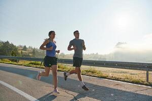 energizado por el belleza de naturaleza, un Pareja potestades mediante su Mañana correr, su cuerpos y espíritu revitalizado. foto