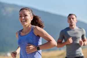 energizado por el belleza de naturaleza, un Pareja potestades mediante su Mañana correr, su cuerpos y espíritu revitalizado. foto