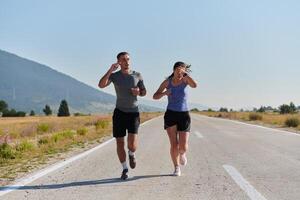 energizado por el belleza de naturaleza, un Pareja potestades mediante su Mañana correr, su cuerpos y espíritu revitalizado. foto