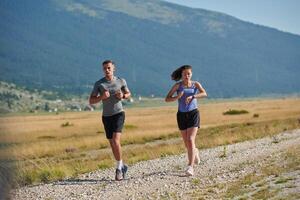 energizado por el belleza de naturaleza, un Pareja potestades mediante su Mañana correr, su cuerpos y espíritu revitalizado. foto