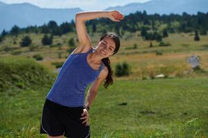 determinado estirar. atlético mujer abraza post-ejecución flexibilidad en naturaleza. foto