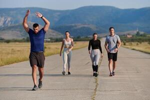 un grupo de amigos mantiene un sano estilo de vida por corriendo al aire libre en un soleado día, unión terminado aptitud y disfrutando el energizante efectos de ejercicio y naturaleza foto