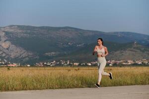 A determined woman athlete trains for success in the morning sun. photo