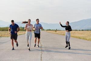 un grupo de amigos mantiene un sano estilo de vida por corriendo al aire libre en un soleado día, unión terminado aptitud y disfrutando el energizante efectos de ejercicio y naturaleza foto