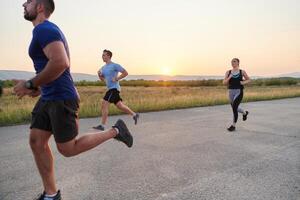 A diverse group of runners trains together at sunset. photo