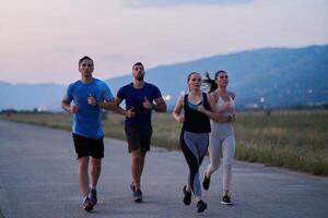 A diverse group of runners trains together at sunset. photo