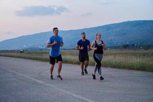 A diverse group of runners trains together at sunset. photo