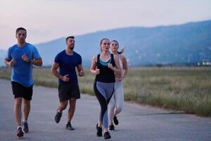 A diverse group of runners trains together at sunset. photo