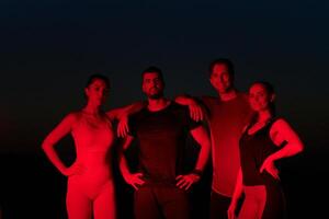 Diverse Athletes Unwind. Post-Marathon Rest Under Red Nighttime Glow. photo