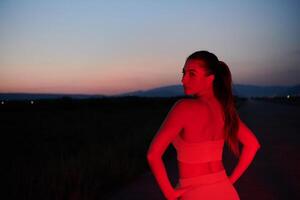 Athlete Strikes a Pose in Red-Lit Nighttime Glow photo