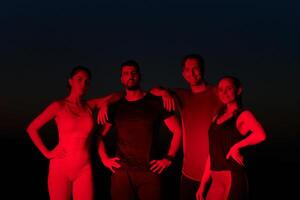 Diverse Athletes Unwind. Post-Marathon Rest Under Red Nighttime Glow. photo