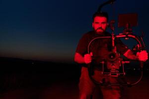 Noche captura. profesional camarógrafo Película (s Atletas corriendo en iluminado en rojo oscuridad foto