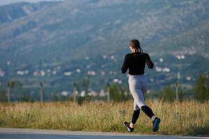 A determined woman athlete trains for success in the morning sun. photo