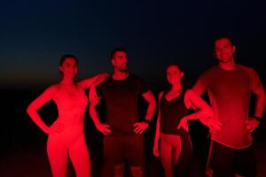 Diverse Athletes Unwind. Post-Marathon Rest Under Red Nighttime Glow. photo