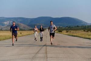 un grupo de amigos mantiene un sano estilo de vida por corriendo al aire libre en un soleado día, unión terminado aptitud y disfrutando el energizante efectos de ejercicio y naturaleza foto