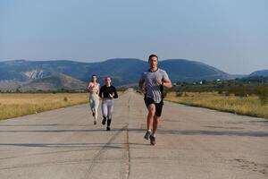 A group of friends maintains a healthy lifestyle by running outdoors on a sunny day, bonding over fitness and enjoying the energizing effects of exercise and nature photo