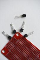 Red printed circuit board and chips and radio components. Capacitors and transistors. photo