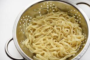Boiled noodles in a colander for cooking. photo