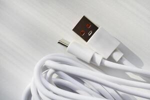 USB cable on a white background. A white prod for the phone. photo