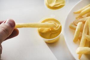 French fries on a white plate with sauce. Delicious fried crispy potatoes. photo