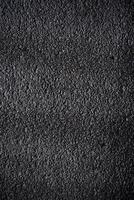 Black porous porous foam background. Background texture of black foam rubber photo