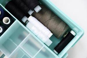 A set of colorful sewing threads. Skeins of thread in a plastic box. photo