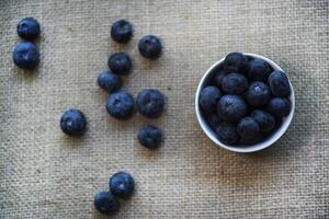 Blueberries in a white bowl on a burlap tablecloth. Juicy blueberries. photo