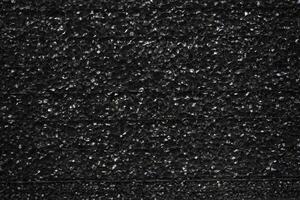 Black porous porous foam background. Background texture of black foam rubber photo