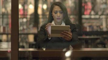 ung attraktiv affärskvinna använder sig av läsplatta dator inuti bar lobby video