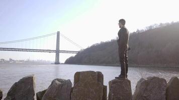 estilo de vida retrato do homem dentro terno desfrutando rio ponte panorama ao ar livre video