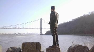 mode de vie portrait de homme dans costume profiter rivière pont paysage en plein air video