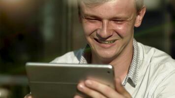 Jeune homme ayant une appel sur mobile tablette écran parlant video