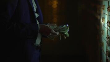 A man in a suit counting money in a dimly lit locker room, symbolizing financial security video