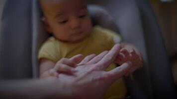 bebis barn pojke innehav fäder hand ser på fingrar video
