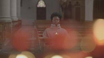 jung afrikanisch Frau mit lockig Haar beten Innerhalb Kirche video