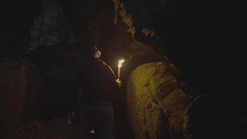 Man Holding A Burning Torchlight Exploring Forest Cave Landscape In Dark Night video