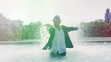 Happy Young Man Dancing in Water Fountain in Summer Time video