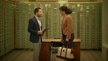 a man is talking to a woman in a bank vault video