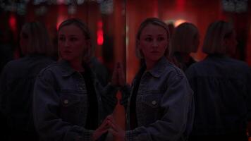 jong blond vrouw verkennen kamer van spiegels in droomachtige fantasie neon licht video