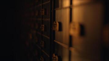 A row of safes in a dark room, casting shadows on hardwood floor video