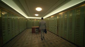 A man in a suit walks down a hallway in a building with a briefcase video