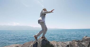 Carefree male person in retro style walking at lake pier outdoors video